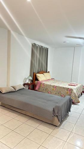 a bedroom with two beds in a room at Loft Studio Central in Nova Friburgo