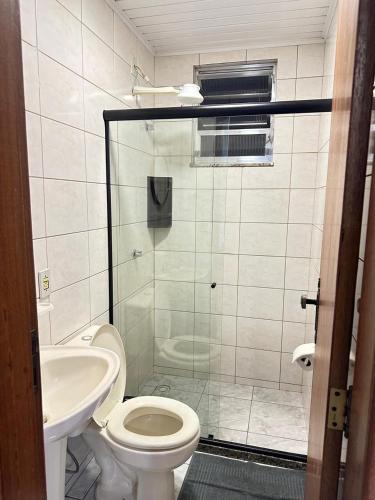 a bathroom with a shower and a toilet and a sink at Loft Studio Central in Nova Friburgo