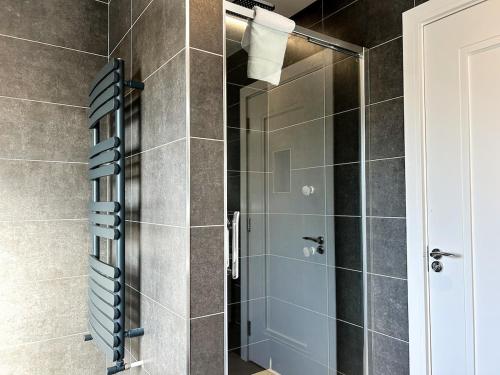 a shower with a glass door in a bathroom at Central Haven Dingle in Dingle