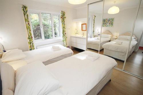 a room with three beds and a mirror at 3 Bed in Mumbles oc-hh19 in The Mumbles