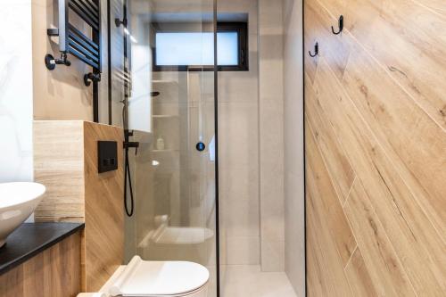 a bathroom with a toilet and a glass shower at Czerwone Wierchy Premium Apartment in Zakopane