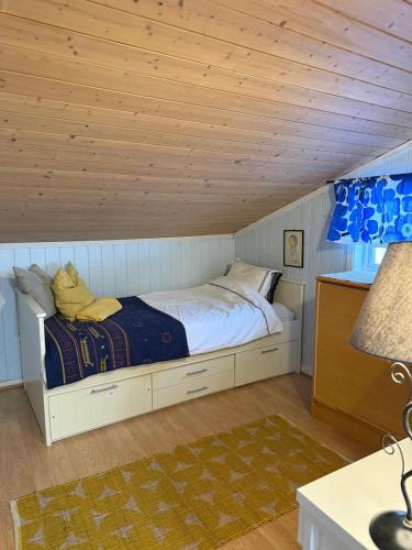 a bed in a room with a wooden ceiling at Koia Guesthouse in Flesberg