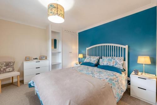 a bedroom with a large bed with a blue wall at 1 Bed in Drefach oc-m30848 in Llanwenog