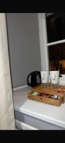 a tray with three cups on a window sill at The Turf Hotel in Richmond