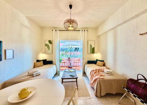 a living room with two beds and a table at 2BR a 400m da praia Surf e Relax a 50min de Lisboa in Santa Cruz