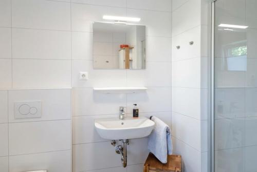 a white bathroom with a sink and a shower at Haus Dornröschen in Schweiburg