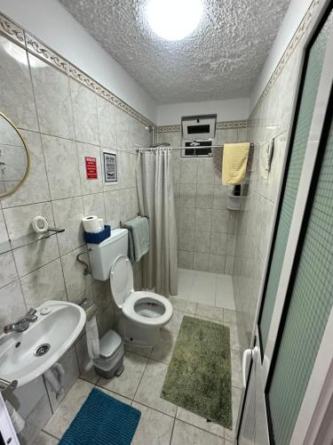 a bathroom with a toilet and a sink and a shower at 2 bed room apartment , sea view, 10 minutes walk to the beach in Ribeira Brava