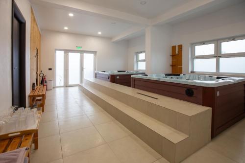 a large bathroom with a large tub and sinks at Pensiunea Andreea in Baia de Fier