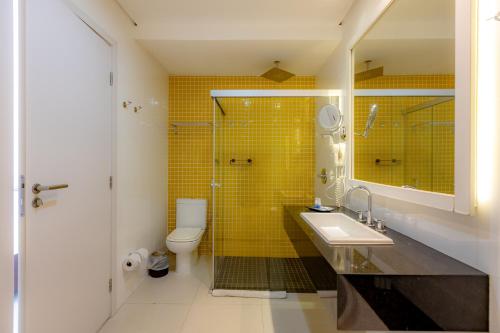 a bathroom with a sink and a shower and a toilet at Guarujá Vivah in Guarujá