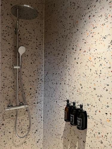 eine Dusche mit drei Shampooflaschen an einer Wand in der Unterkunft Kaffee Changé in Gent