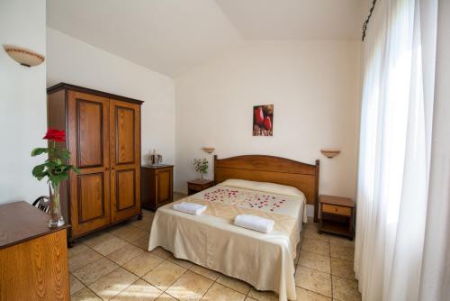 a bedroom with a bed and a dresser in it at Hotel Perda Rubia in San Giovanni Suèrgiu