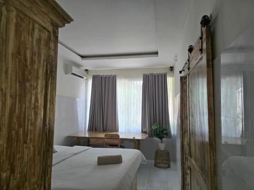 a bedroom with a bed and a table in it at Rumah Risa in Tanah Lot