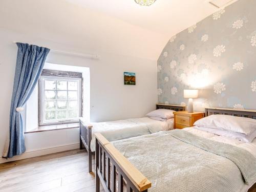 a bedroom with two beds and a window at 2 Bed in Matlock oc-81043 in Winster