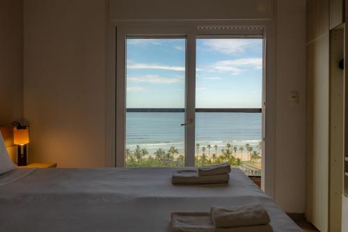 a bedroom with a bed with a view of the ocean at Guarujá Vivah in Guarujá