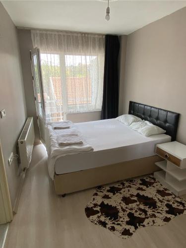 a bedroom with a bed and a window and a rug at TANER PANSİYoN in Edirne