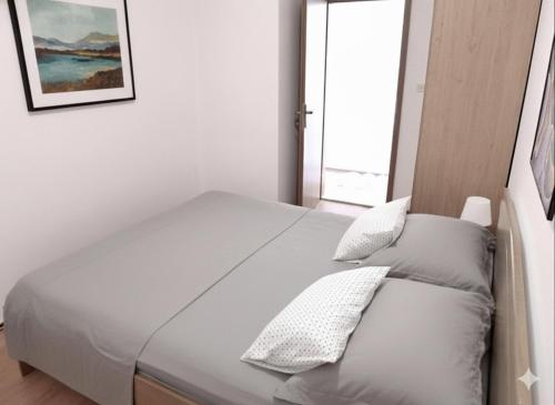 a bedroom with a bed with white sheets and pillows at Apartman Castil in Bol