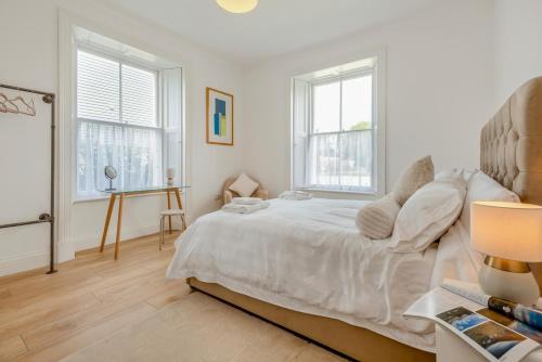 a white bedroom with a bed and two windows at 2 Bed in Cockermouth oc-m32942 in Cockermouth