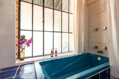 a blue tub in a bathroom with a window at Hotel La Posada del Valle in Tepoztlán