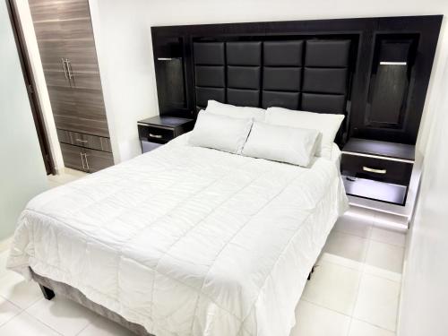 a bedroom with a large white bed with two pillows at Apartamento Premier in Ibagué