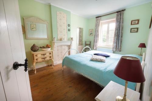a bedroom with a bed and a mirror and a window at Hof ter Wallen in Zoutleeuw