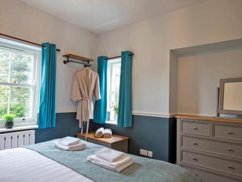 a bedroom with a bed with blue curtains and a dresser at 7 Bed in Buxton oc-93808 in Tideswell