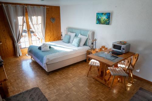 a bedroom with a bed and a table with a microwave at Le Vieux Valais in Ovronnaz