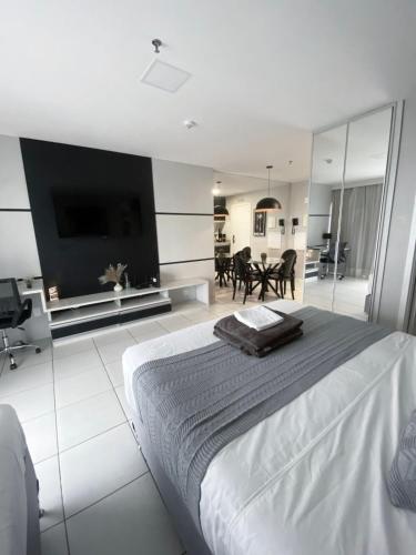a white bedroom with a large bed and a tv at Flat com vista espetacular no centro de Brasília Vision Work and live in Brasília