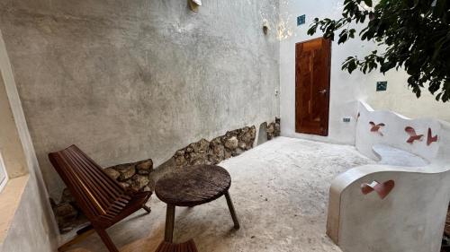 a room with a bench and a chair and a wall at Calle Ouvert in Mérida
