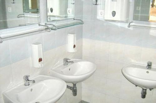 a bathroom with two sinks and two mirrors at Karavan AIDA in Živogošće