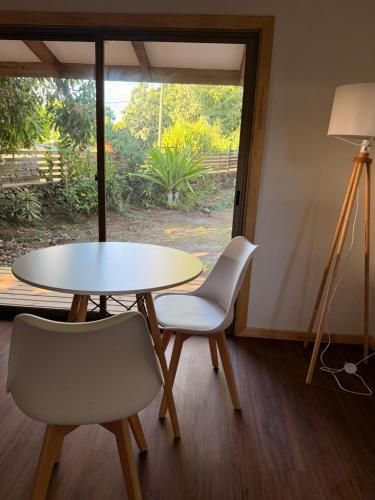 a table and two chairs in a room with a window at Cabañas Mahatua in Hanga Roa
