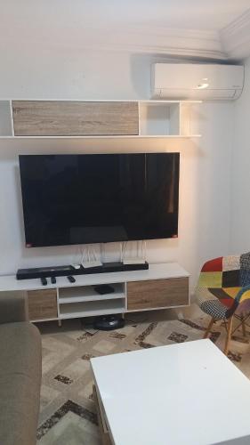 een woonkamer met een grote flatscreen-tv bij M&D hebergement in Dakar