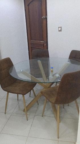 een glazen eettafel met twee stoelen en een tafel bij M&D hebergement in Dakar