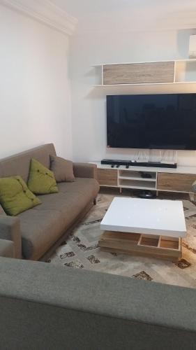 Una sala de estar con un sofá y un televisor de pantalla plana. en M&D hebergement, en Dakar