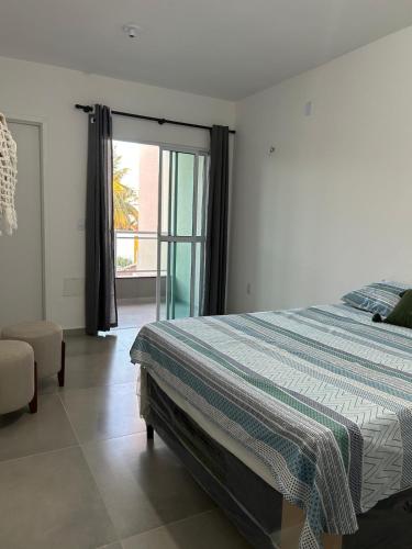 ein Schlafzimmer mit einem Bett und einer Glasschiebetür in der Unterkunft Frida's Corner in Caucaia
