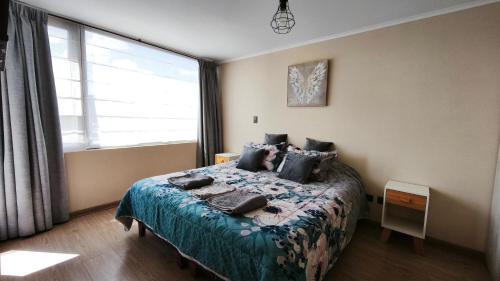 a bedroom with a bed and a large window at Departamento centro Temuco in Temuco