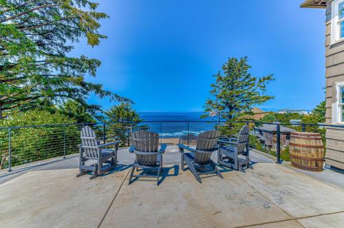 Eine Terrasse mit drei Stühlen, einem Tisch und Meerblick in der Unterkunft Oceanside Skies in Oceanside