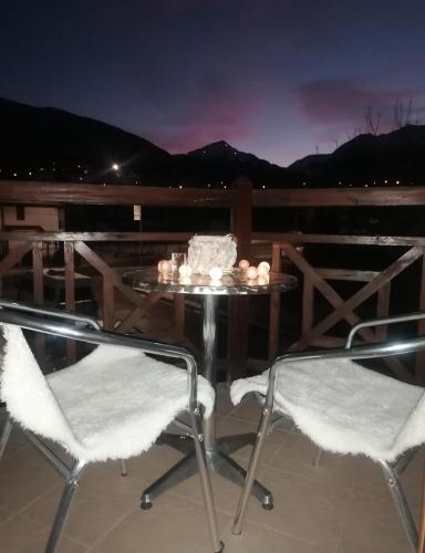 a table and two chairs on a deck at night at Mountain View Apartment Bansko in Bansko