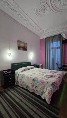 a bedroom with a large bed with a floral bedspread at Cenário Catita Hostel in Lisbon
