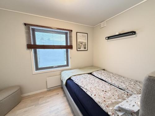 a small bedroom with a bed and a window at Modern brand new apartment Kongsberg in Kongsberg