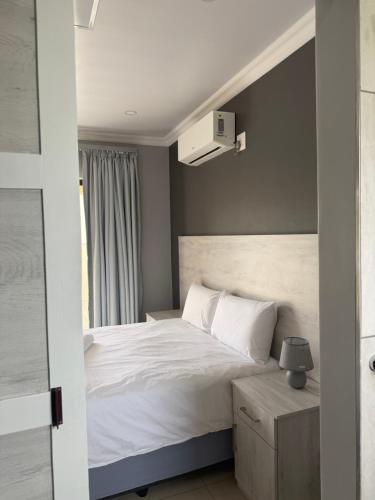 a bedroom with a white bed and a window at M & N Guest House in Ermelo