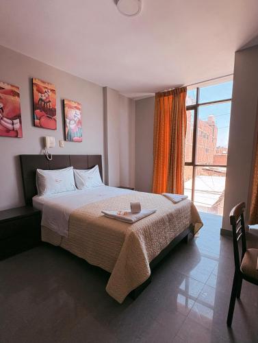 a bedroom with a bed and a large window at HOTEL ALFONSO UGARTE in Chiclayo