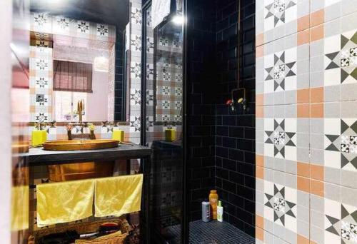 a bathroom with a sink and a tiled wall at Alojamiento Simón 2 in Murcia
