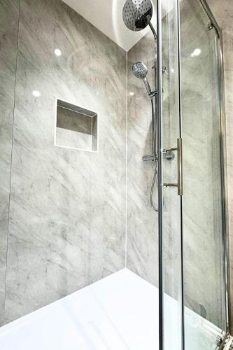 a bathroom with a shower with a glass door at The Lockside By Allsquare Stays 5BDR Heathrow M4 M25 M3 in Staines
