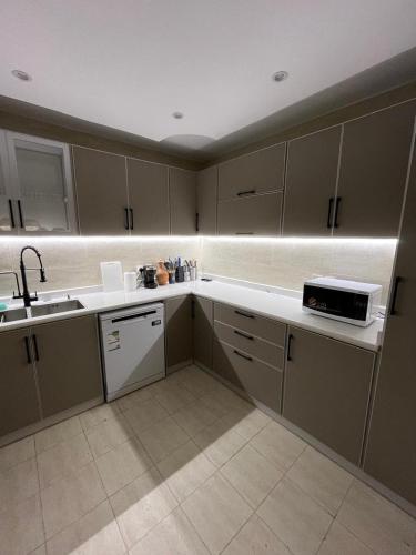 a kitchen with a sink and a microwave at Izdihar Dalis Suites in Quai