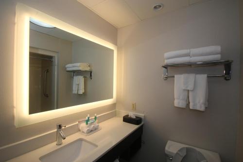 een badkamer met een wastafel, een spiegel en handdoeken bij Holiday Inn Express Hillsville, an IHG Hotel in Hillsville