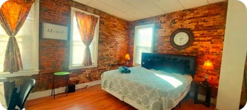a bedroom with a bed and a brick wall at Charm's City Cozy Studio in Baltimore