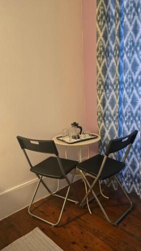 a table and two chairs in a room with a sink at Cenário Catita Hostel in Lisbon