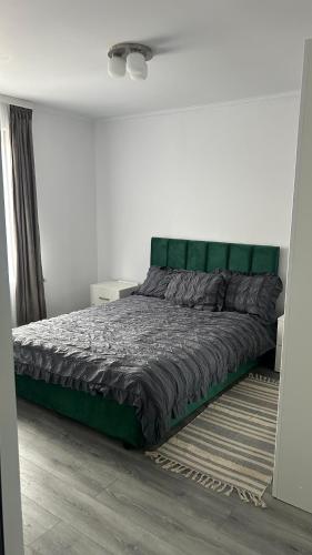 a bed with a green headboard in a bedroom at Palko Residence in Ocna-Mureşului