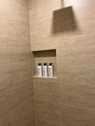 a bathroom with a shower with three shampoo bottles at Executive Loft - Gym - Home Office - Zibatá in La Cañada
