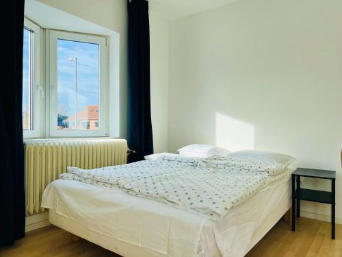 a white bed in a room with a window at COZY ROOM in Helsingborg in Helsingborg
